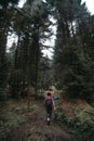 A woman with a backpack, a hiker, walks along a stony path in the middle of a dense forest. travel concept. Trail to Shdugra Royalty Free Stock Photo