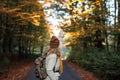 Woman with backpack,jacket, scarf and knit hat hiking on road in autumn forest Royalty Free Stock Photo