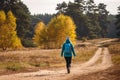 Woman with backpack and knit hat walking on path in woodland Royalty Free Stock Photo