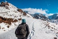 A woman with a backpack makes a climb in the mountains. Traces on snow Royalty Free Stock Photo