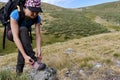 Woman with backpack tying boot laces during a hike in mountain. Royalty Free Stock Photo