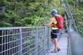 Woman with backpack and via ferrata gear looks up on a steel bridge at Lehner Wasserfall via ferrata route in Tyrol, Austria.