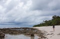 A woman with a backpack walking on a beach in Tonga Royalty Free Stock Photo