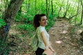 a woman with a backpack walks on the road in the woods hiking journey on foot