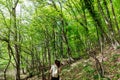 a woman with a backpack walks on the road in the woods hiking journey on foot