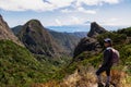 Woman with backpack watching volcanic rock formations in Garajonay National Park seen from Roque de Agando, La Gomera