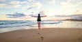 Woman backpacker greeting a sunset at the ocean coast