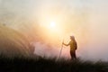 Woman backpacker hiking on mountain peak cliff in the mist