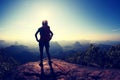 Woman backpacker hiking on mountain peak cliff