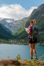 Traveling Norway Woman Backpacker looks at the map,Fologefonna glacier Sandvevatnet lake. Odda Norway