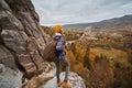 Woman backpacker standing on top of cliff in autumn landscape with valley mountains view Royalty Free Stock Photo