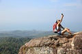 Woman backpacker taking photo with cellphone on mountain peak Royalty Free Stock Photo