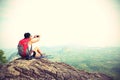 Woman backpacker taking photo with cellphone on mountain peak Royalty Free Stock Photo