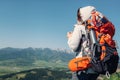 Woman backpacker traveler drinks hot tea on the mountain top