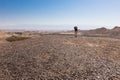 Woman backpacker walking desert.