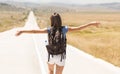 Woman backpacker walking on road and arms open Royalty Free Stock Photo