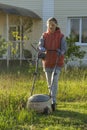 Woman in backyard mowing grass lawn mower Royalty Free Stock Photo