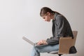 Woman with bad posture using laptop while sitting on chair against light grey background, space for text Royalty Free Stock Photo