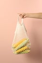 Woman with bag of corn cobs on pink background, closeup Royalty Free Stock Photo