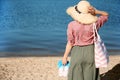 Woman with bag and flip-flops on beach Royalty Free Stock Photo