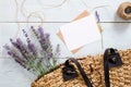 Woman bag with lavender flowers, blank paper card and envelope on blue wooden desk. Flat lay, top view, overhead Royalty Free Stock Photo