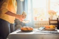 Woman bake fragnant pie and sprinkle the homemade pie with powdered sugar