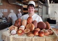 Woman baker with bread products in bakery