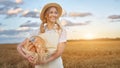 Female farmer standing wheat agricultural field Woman baker holding wicker basket bread product Royalty Free Stock Photo
