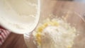 Woman baker sifting flour for dough through bolter.