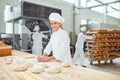 A woman baker smileswith colleagues at a bakery.