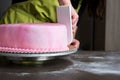 woman in bakery decorating heart shaped wedding cake with pink fondant Royalty Free Stock Photo