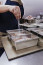 Woman in bakery preparing sweets adding sugar