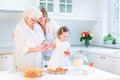 Woman baking cake with senior mother, grand daughter