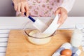 Woman baking and mixing flour with milk