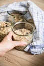 Woman baking raw bread dough with chia, oats, flaxseeds, sunflower and pumpkin seeds in mason glass jar for canning and prepper