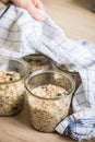 Woman baking raw bread dough with chia, oats, flaxseeds, sunflower and pumpkin seeds in mason glass jar for canning and prepper Royalty Free Stock Photo