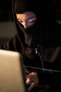 Woman in balaclava using laptop