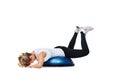 Woman, balance ball and lying workout, balance or exercise on a white studio background. Young person or athlete on half