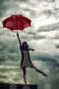 Woman, balance and umbrella on rooftop for weather, adventure and freedom on trip, sky and insurance. Female person