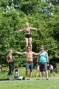 Woman Balances On Shoulders Of Man Practicing Routine In Park