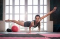 Woman balancing while doing a one hand push up showing strength