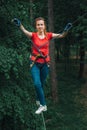 Woman balancing on high in forest adventure rope park