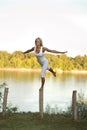 Woman balancing on a post