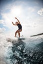 Woman balancing on the wake board on high wave against blue sky Royalty Free Stock Photo