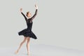 Woman ballet dancer over gray background.