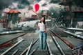 Woman with balloon, airplane crash on background