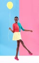 Woman, balloon and smile with colorful clothes for fashion, trendy and playful for outstanding and bold style. African