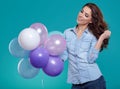 Woman with balloons in studio on a blue background