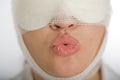 Woman with bandaged face blowing a kiss