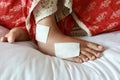 Woman with bandaged foot on bed